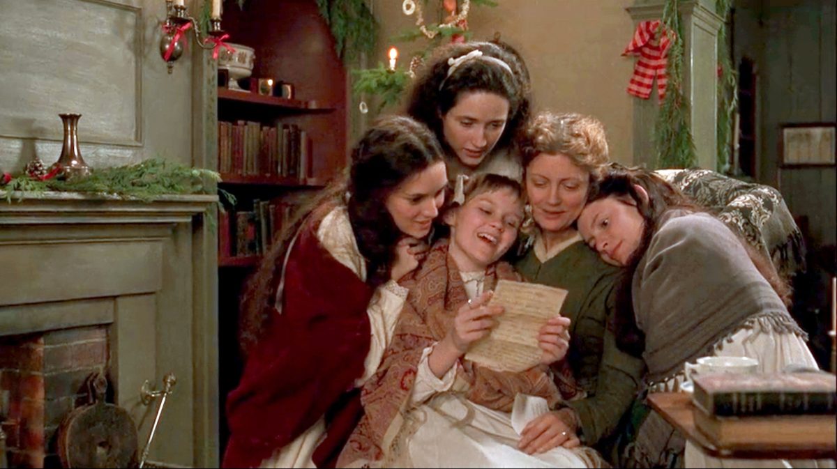 Still from Little Women showing a woman reading a letter surrounded by four young women