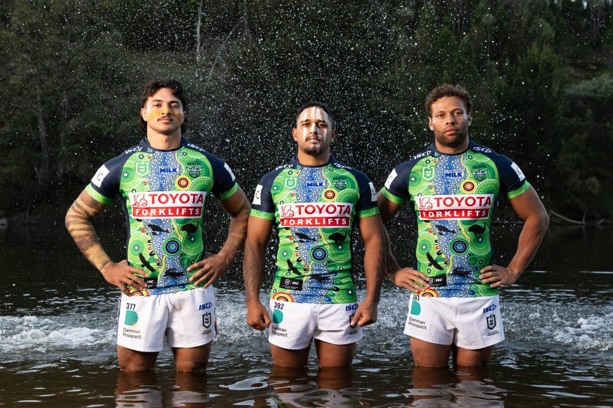 Three men standing in the river with water in the the air
