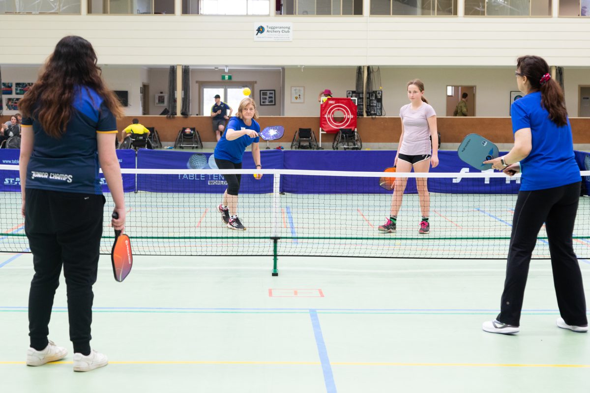 Four people playing pickleball