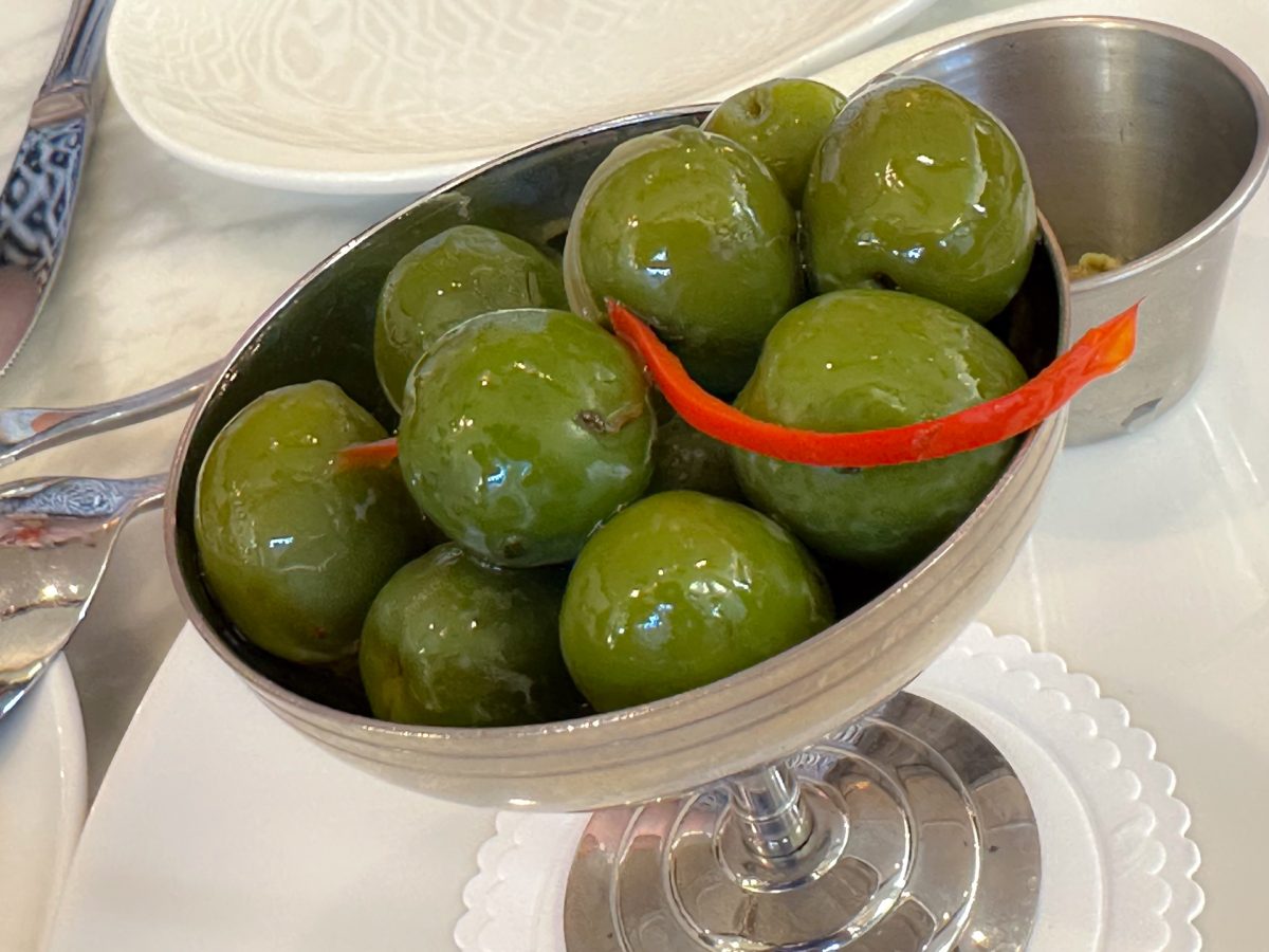 Green olives in small metal dish.