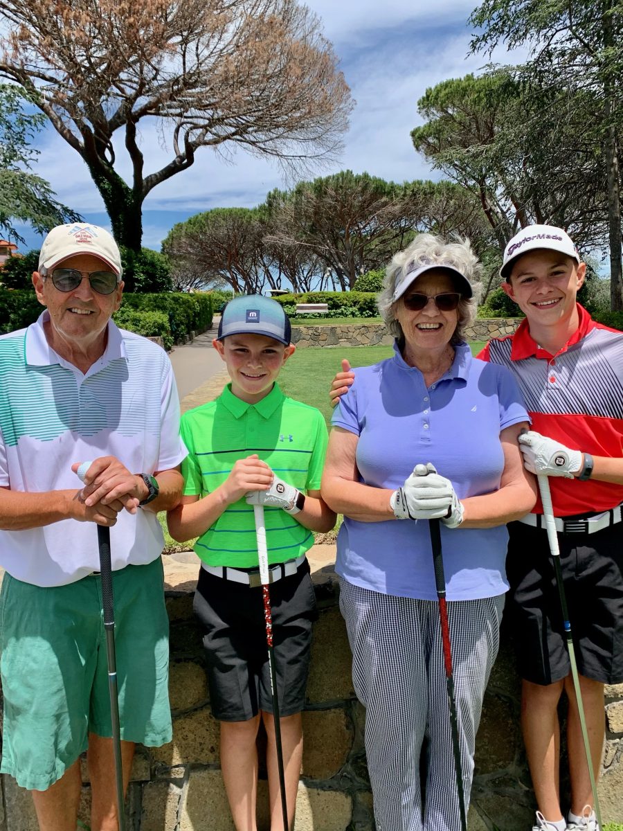 two boys with their grandparents on a golf course