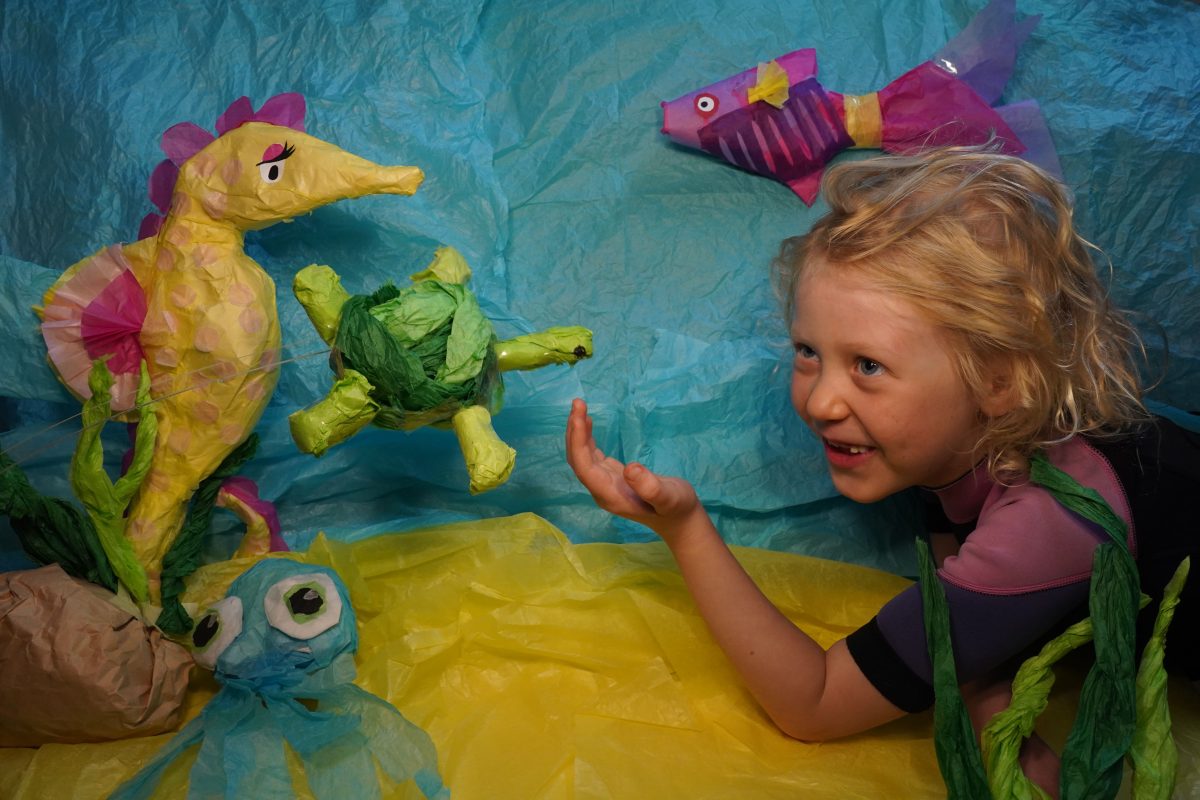 happy girl with sea creature puppets