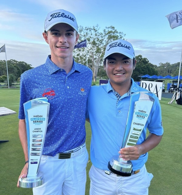 two young men holding trophies