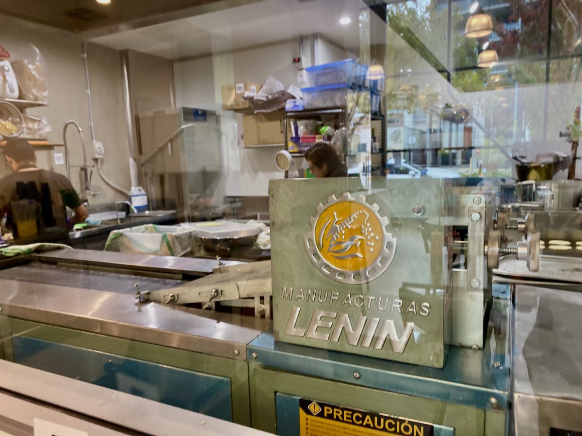 Machine in kitchen with brand 'lenin' and corn logo.
