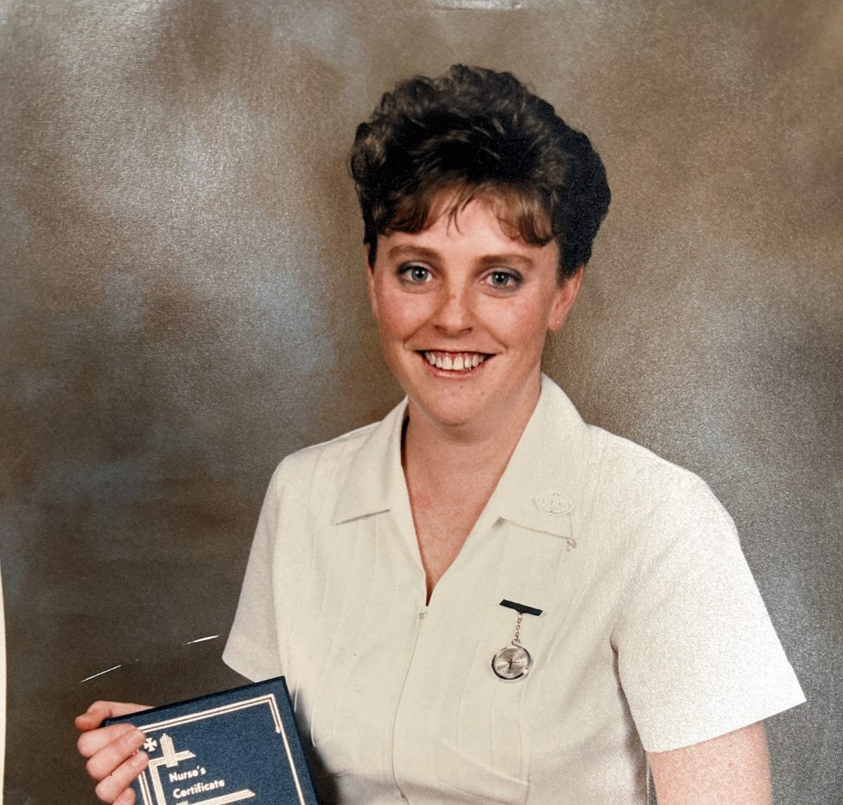 Young nurse holds her diploma of nursing