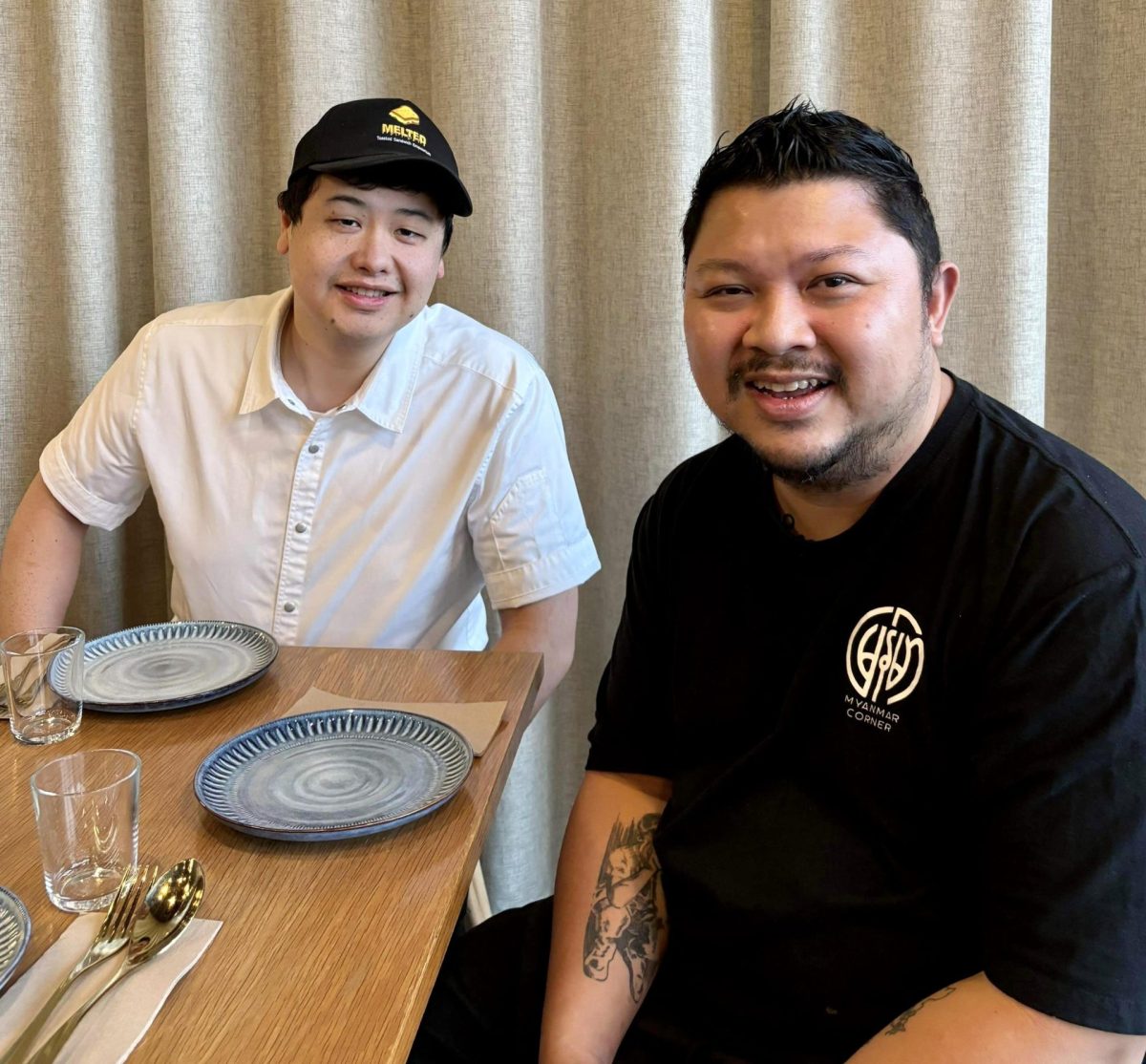 Two men sit at restaurant table.