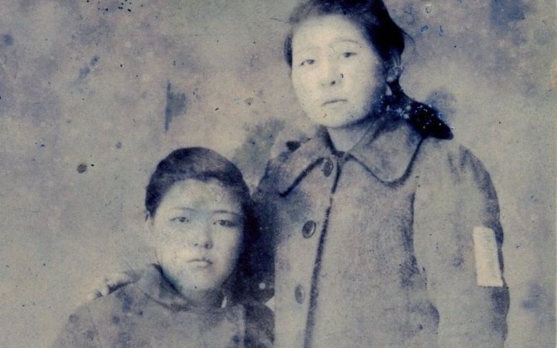 A sepia photograph of a young Japanese girl and boy