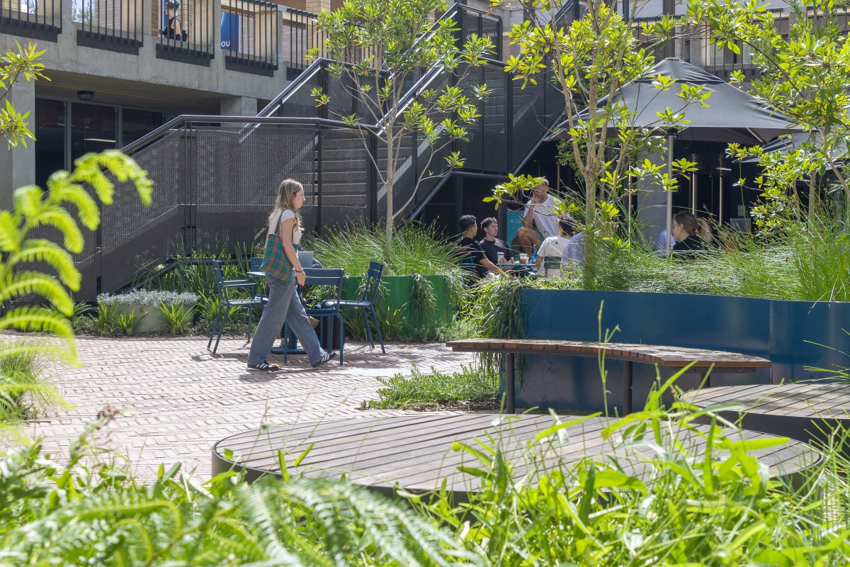 Woman walks through the University of Canberra's HUB precinct