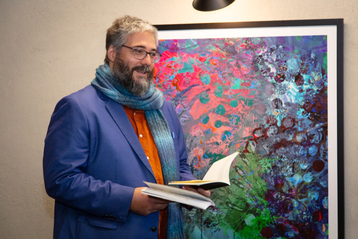 Paul Summerfield reading a poem next to his artwork