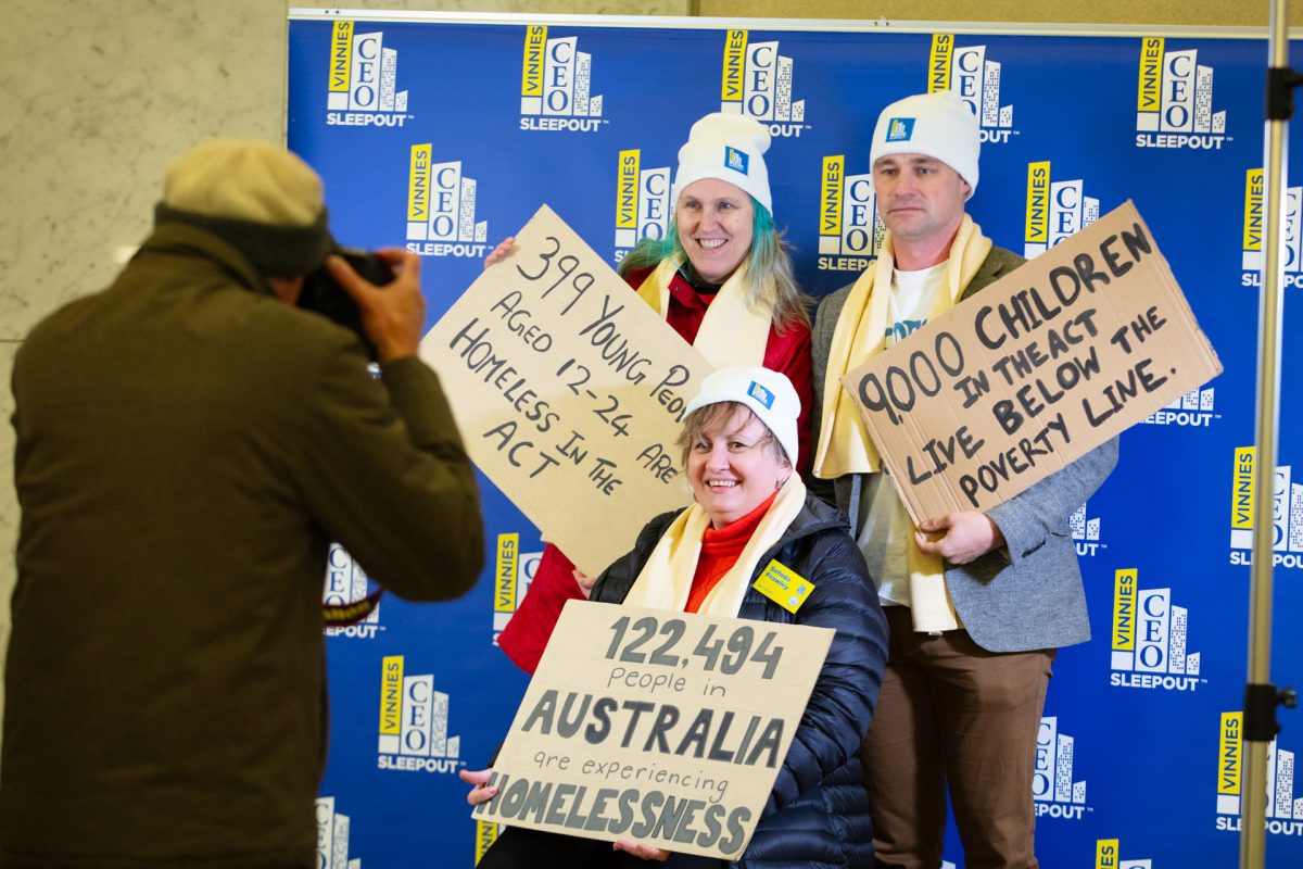 three people holding signs