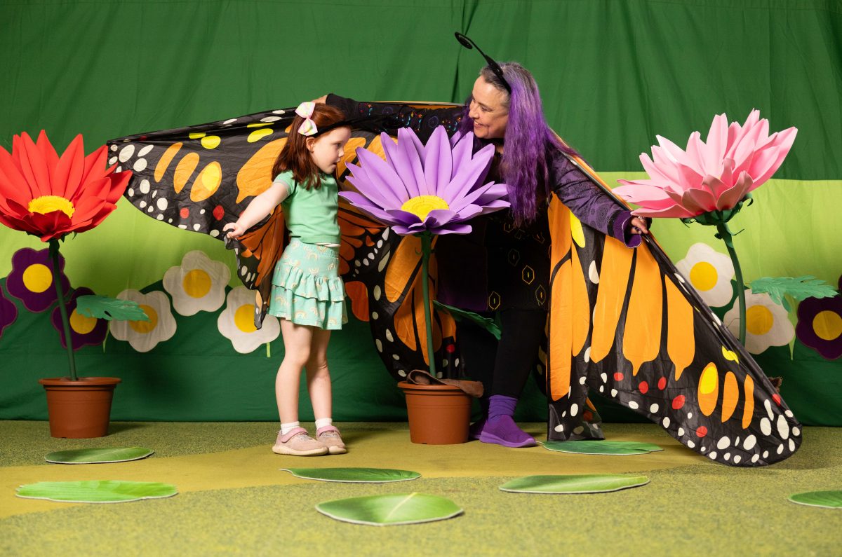performer dressed as butterfly with child