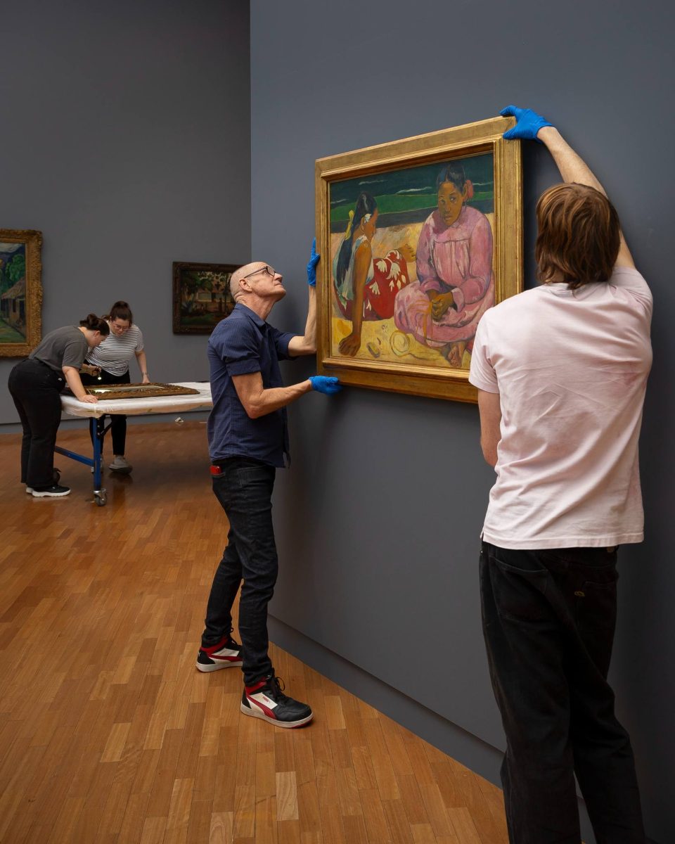National Gallery of Australia staff move artwork Tahitian women into place.