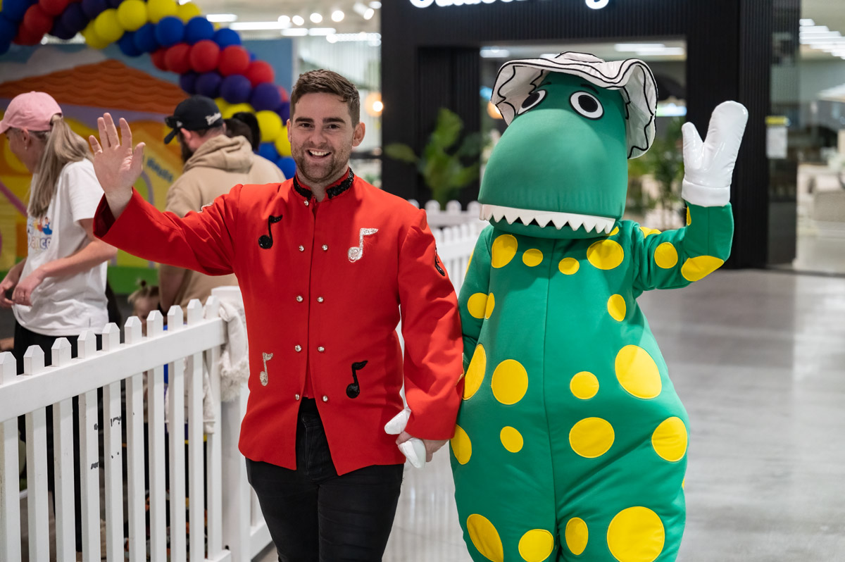 Man stands with Dorothy the Dinosaur