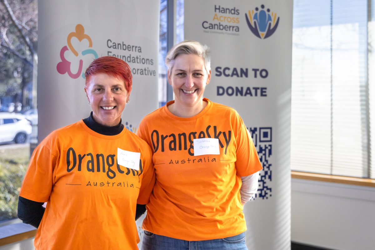 two women wearing orange shirts