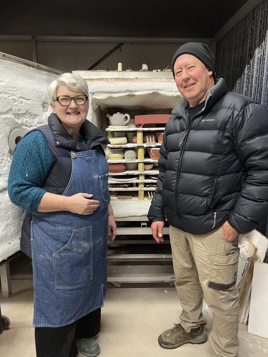 Student potter Veronica Taylor with teacher Chris Harford in front of pottery kiln