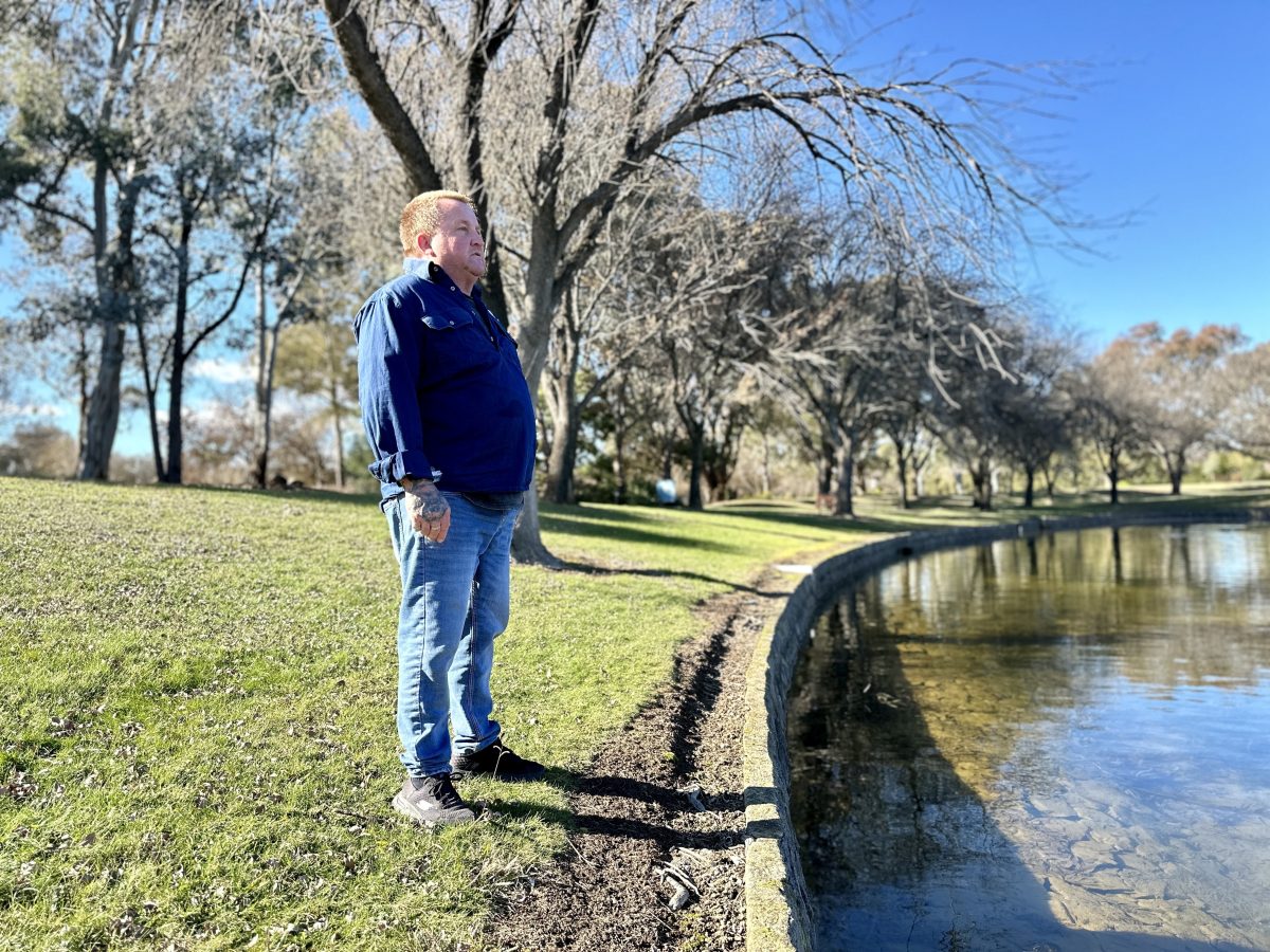 man looking over a pond