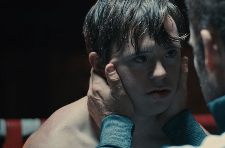 Still from Kairos showing a man holding a boxer's face in his hands and looking into his eyes