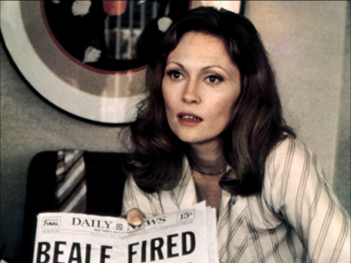 Still from Network showing a woman holding up a newspaper
