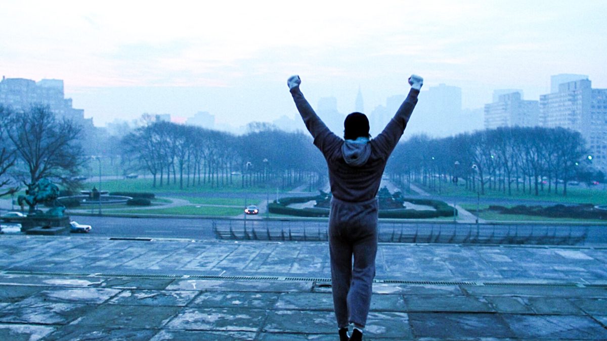 Still from Rocky showing a man raising fists in the air in a foggy city