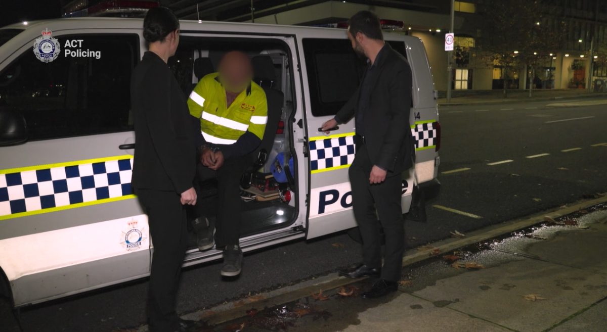 man exiting police van