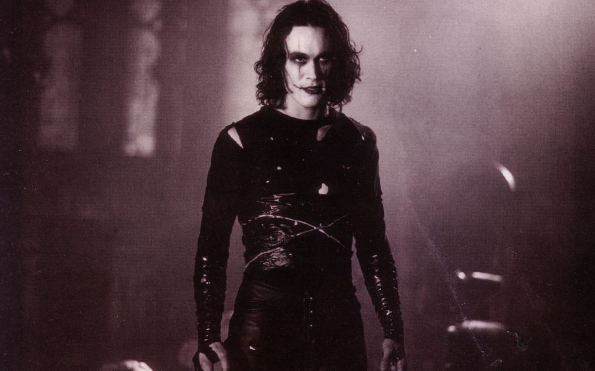 Still from The Crow of a man clad in black with facial scars