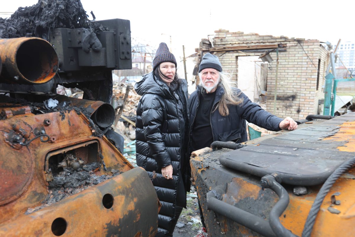 Hellen Rose and George Gittoes amidst burnt-out tanks