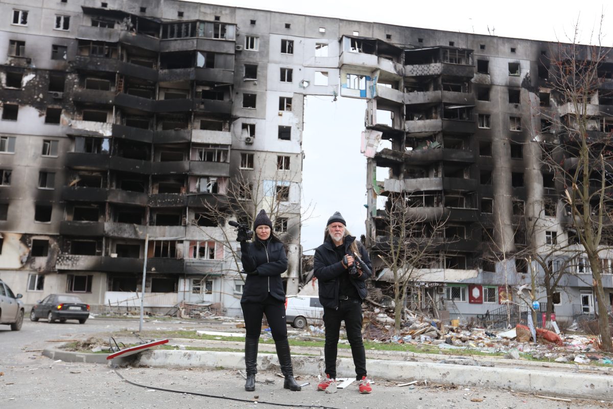 Hellen Rose and George Gittoes standing outside bombed building