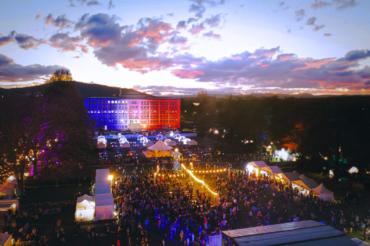 drone shot of crowd standing in a market at night