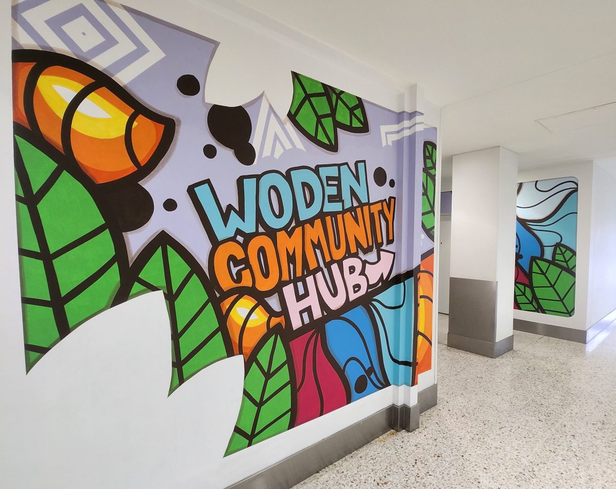 White wall with colourful artwork. Artwork reads 'Woden Community Hub'