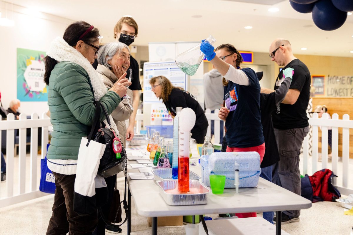 People interacting with science liquids, beakers and measuring glasses