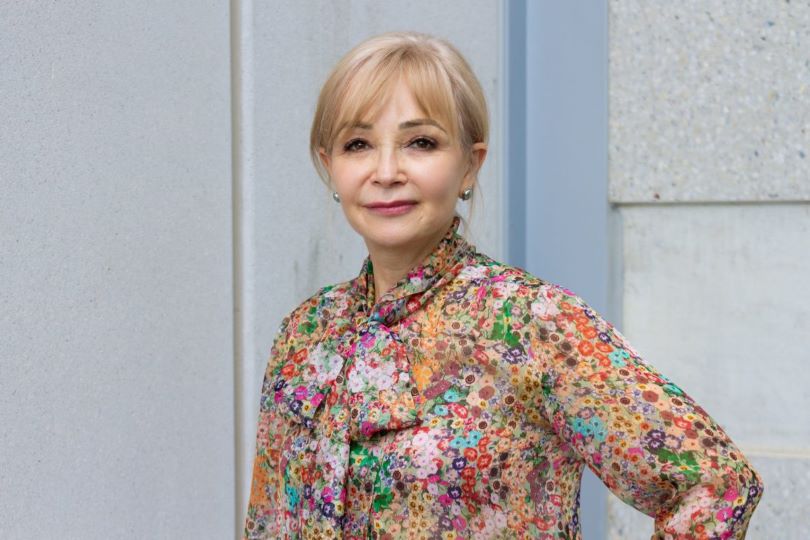 A portrait of a woman in a floral-patterned blouse