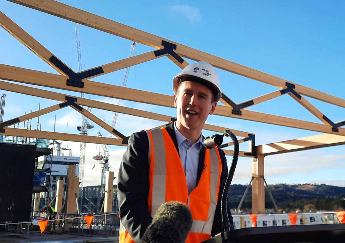 man on building site talking into a microphone