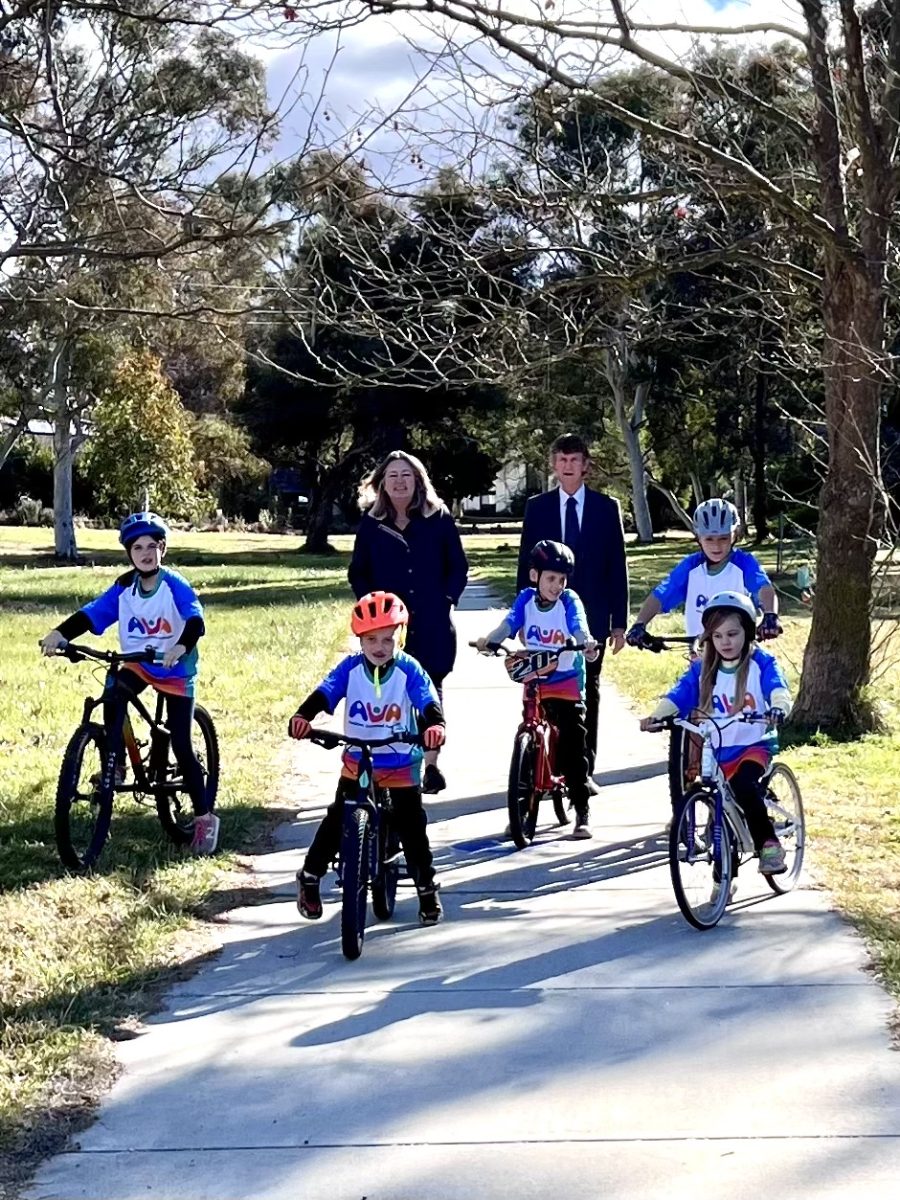 Bike path with kids cycling and a man and a woman walking behind 