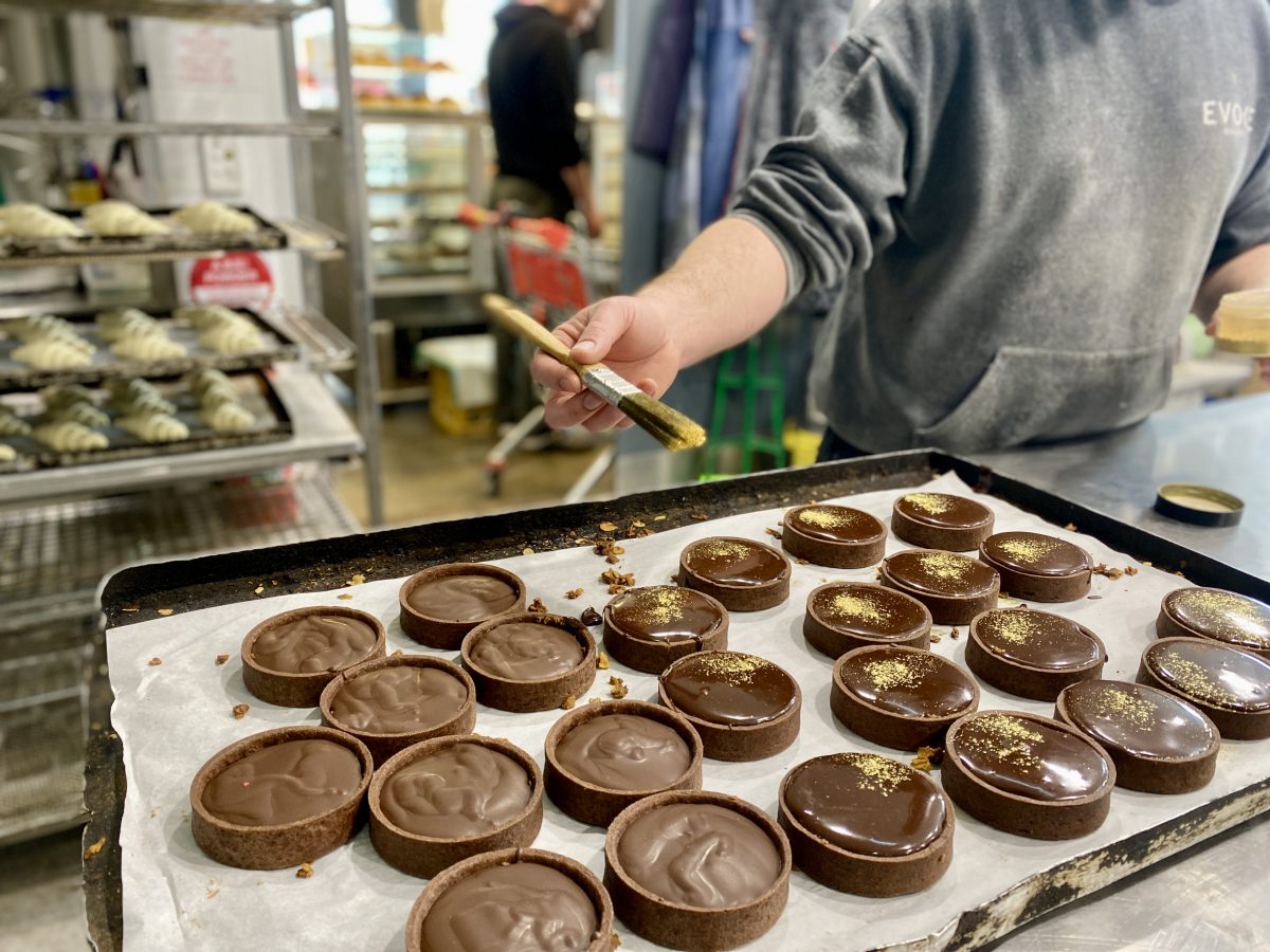 Dusting edible gold onto chocolate tarts.