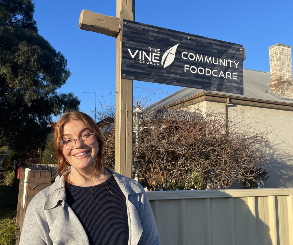 woman in front of sign that says vine community foodcare