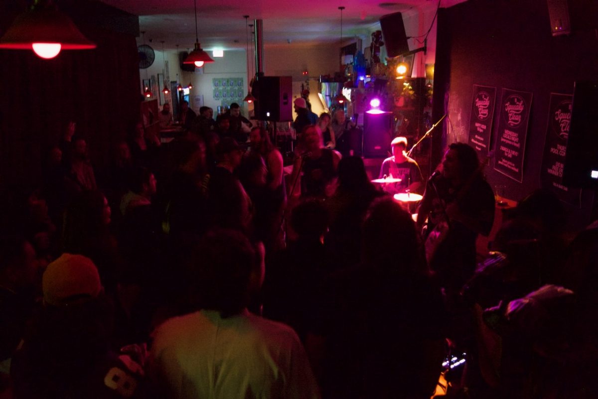 Interior of bar with pink lights and band performing.