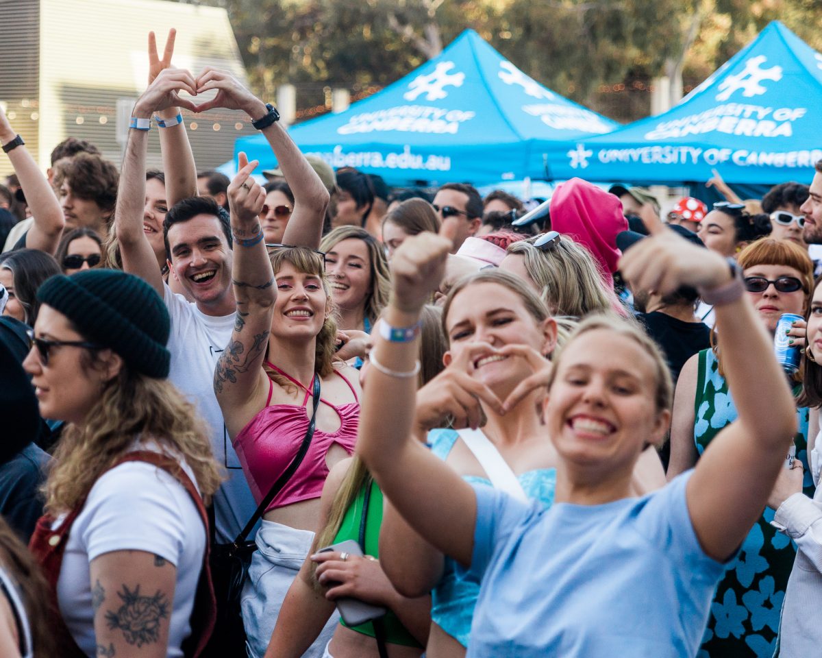 People smiling and raising their arms in the air