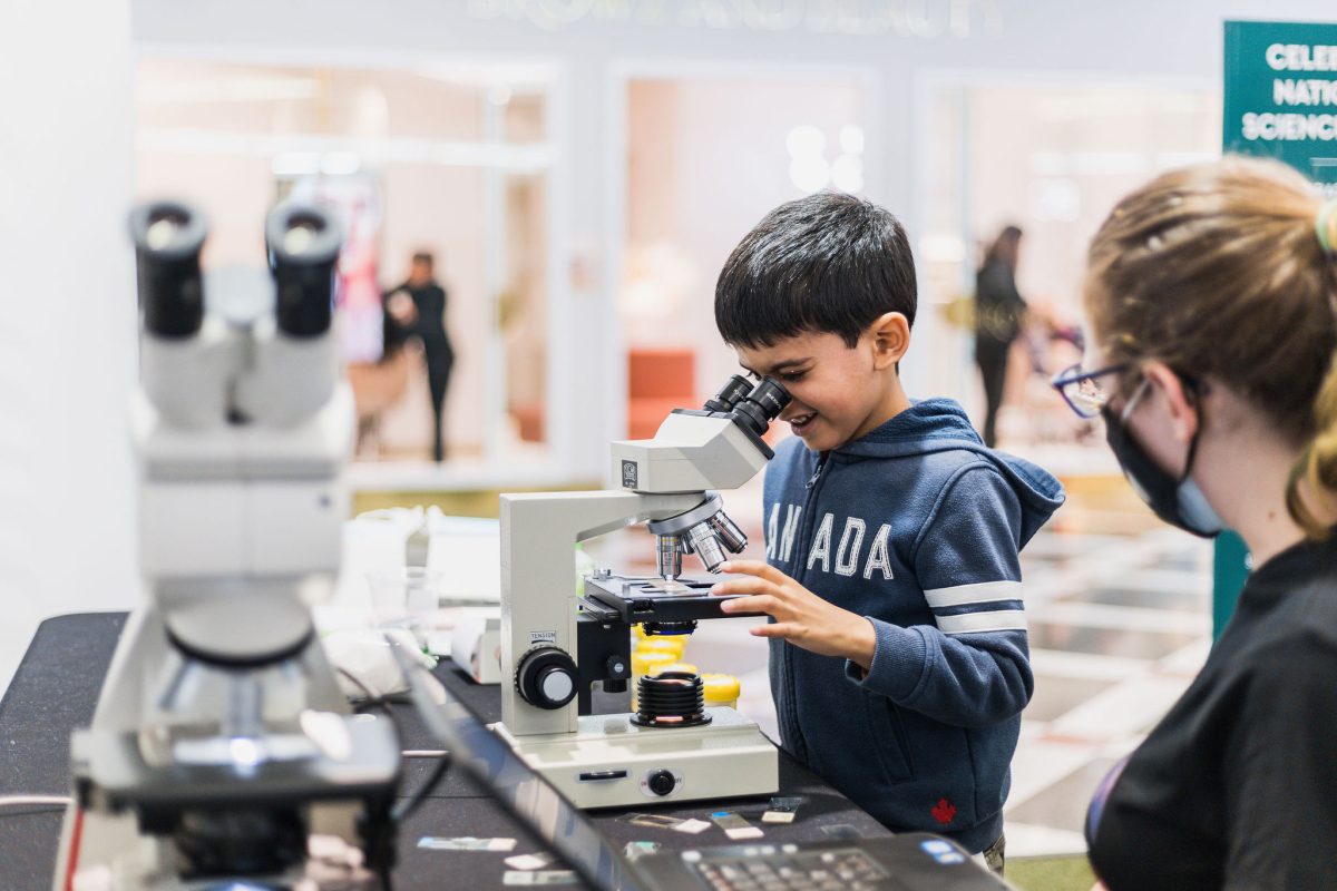 a child looking through a microscope