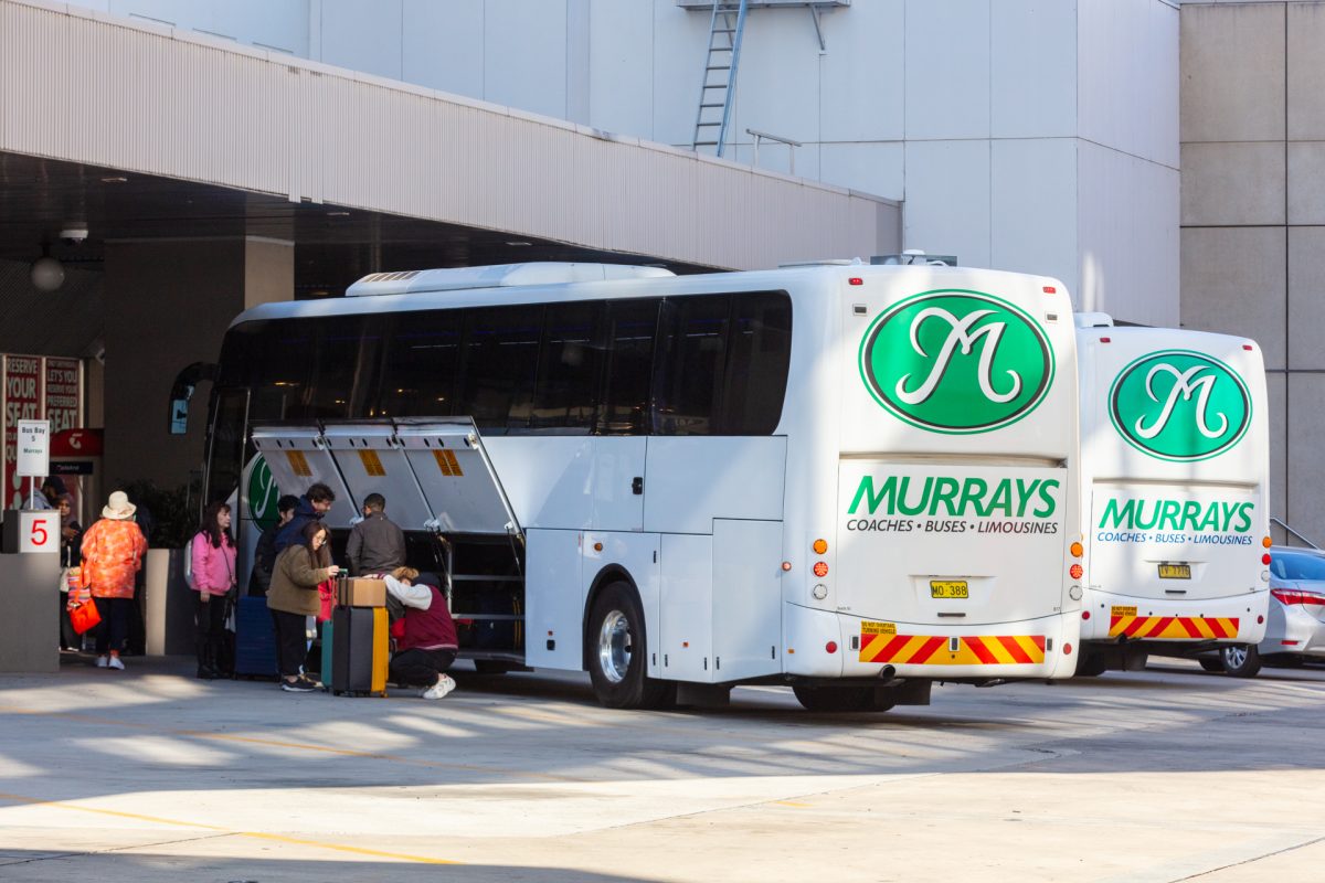 Passengers loading luggage into a Murrays coach