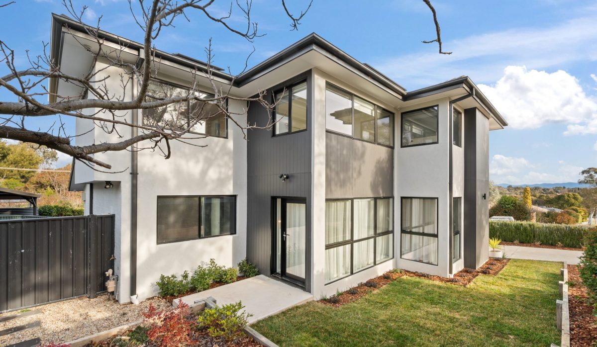 Large white and grey house with grass 