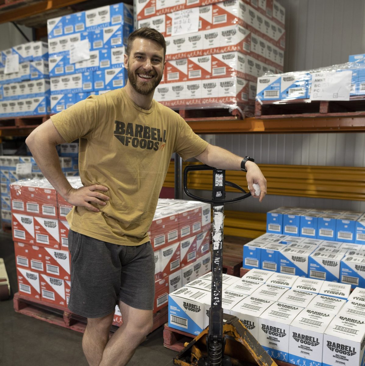 Luke stands next to a palette of boxed biltong.