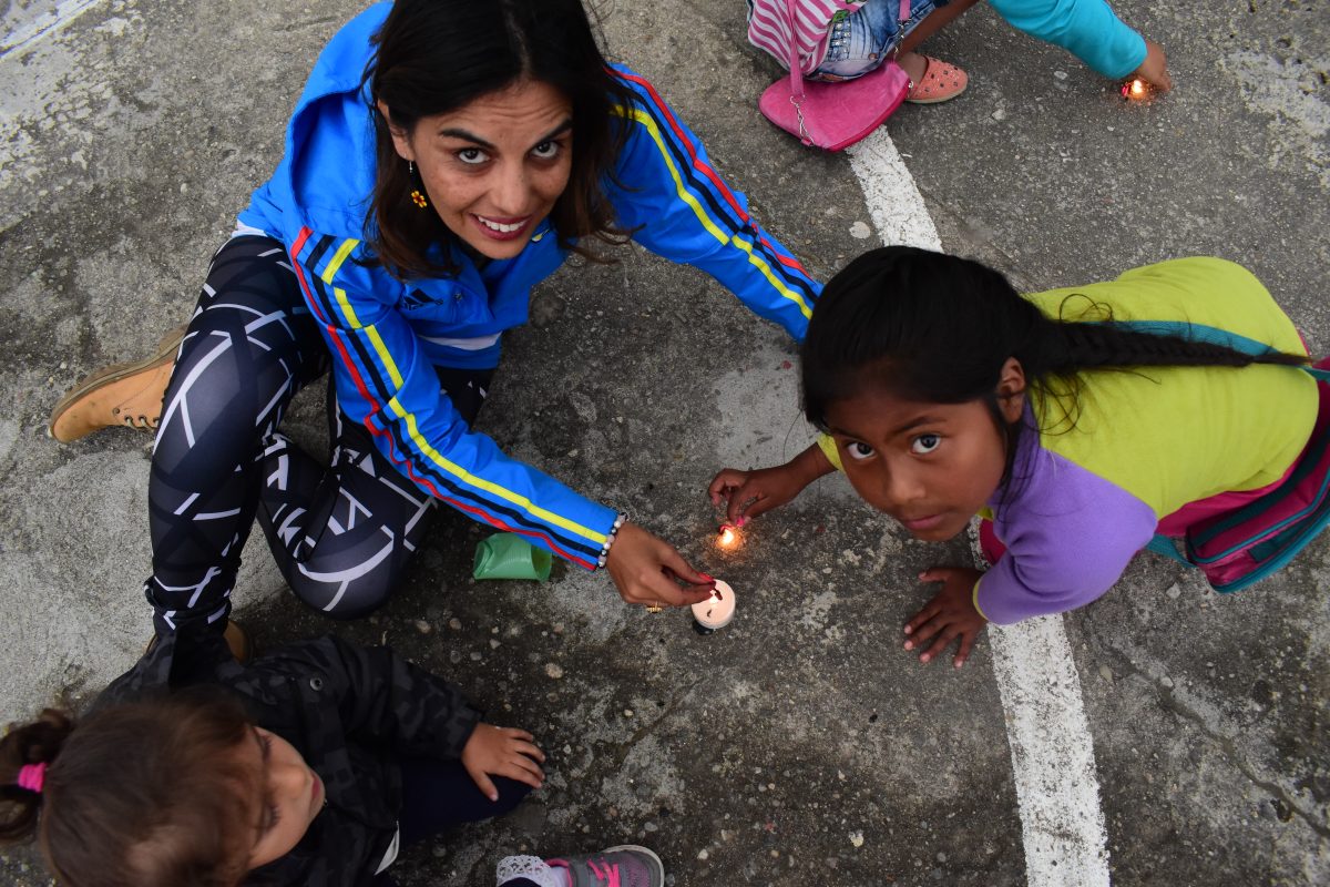 women and child with candle on road 