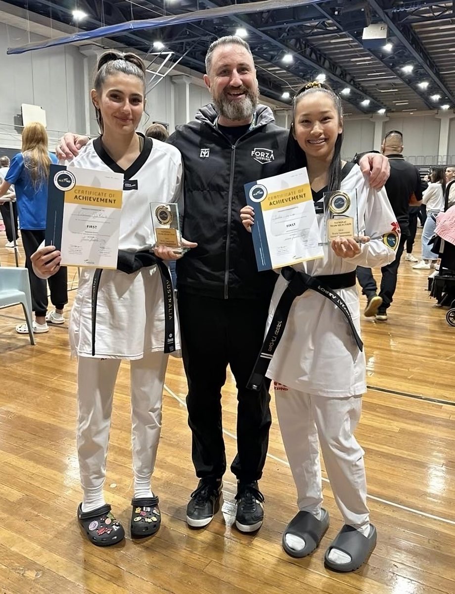 two female taekwondo competitors and their coach