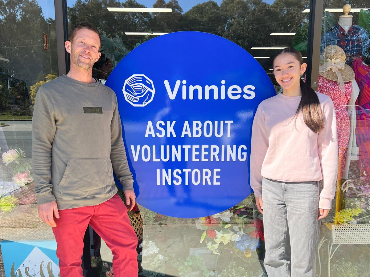 Two people standing in front of sign