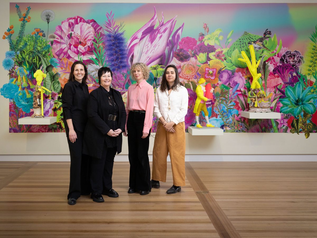 Four women in front of large colourful painting