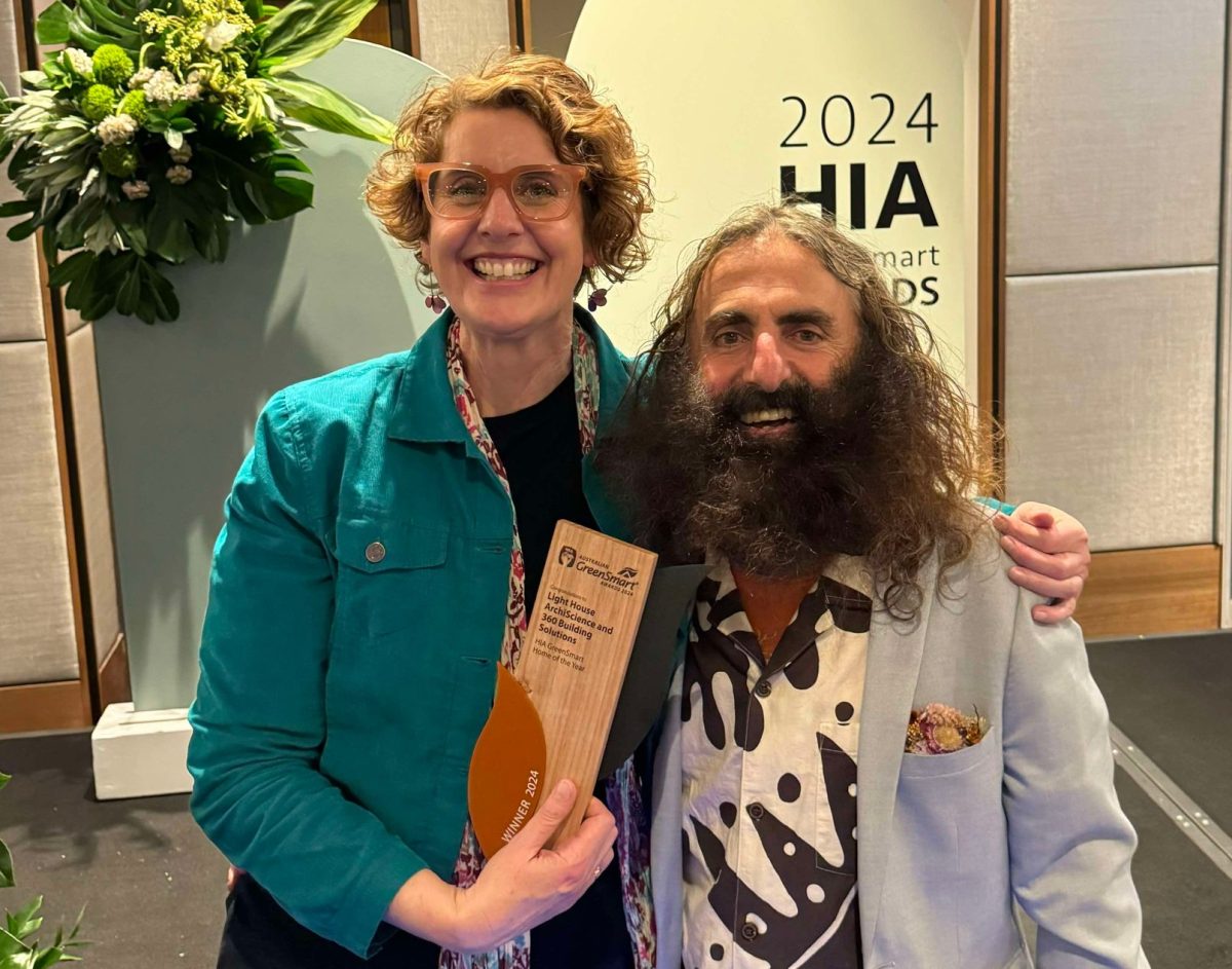 women with award next to a man with an enormous fluffy beard