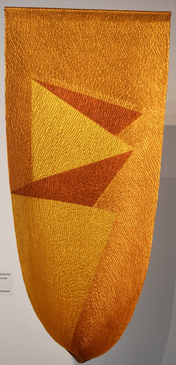 Vertical, golden glowing textile form