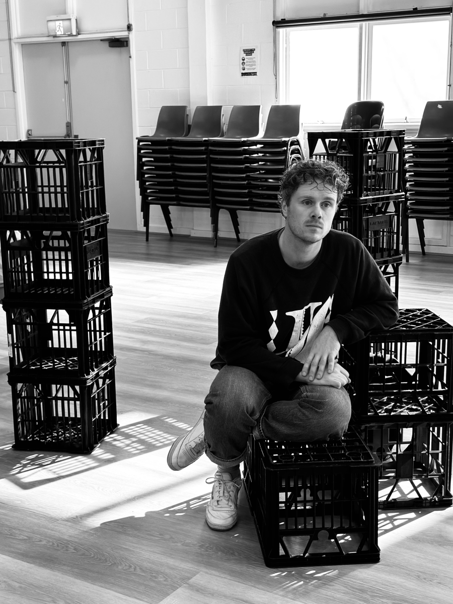 Man sitting on milk crate.