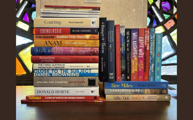 A stack of books in front of stained glass windows