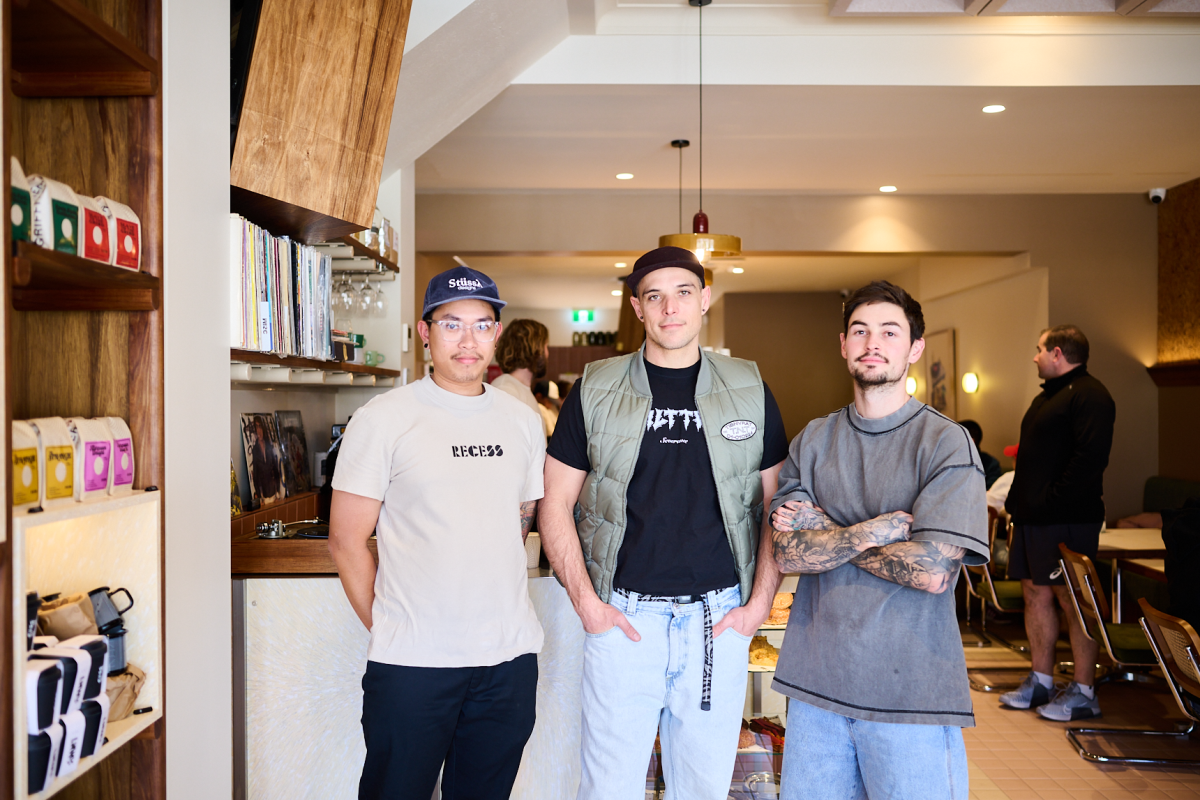 Three men standing in a cafe